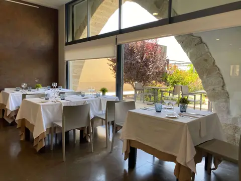 comedor del restaurante bajo los arcos, con ventanal al jardín