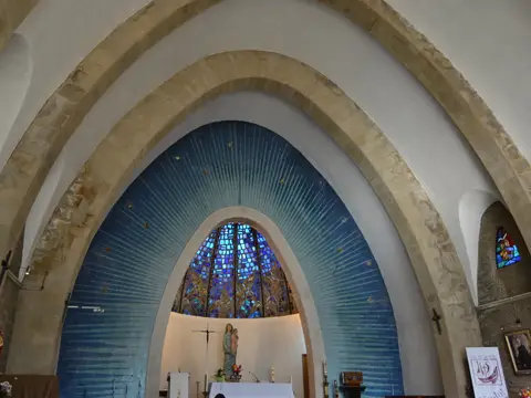 interior del santuario con los arcos parabólicos y el ábside azul