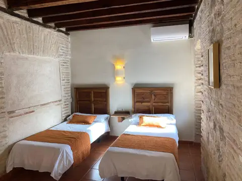 habitación doble, con dos camas y paredes de piedra vista