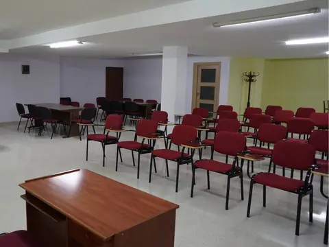 salón de conferencias montado con sillas y mesa presidencial