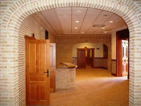 recepción de la Casa de Espiritualidad, con el arco de ladrillo y el mostrador