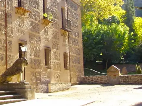 el frente del monasterio desde el camino de entrada, con los leones de piedra y las macetas en los balcones