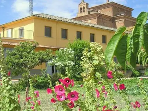 el edificio del monasterio visto desde la huerta, con la espadaña y el cimborrio mudéjar de la iglesia al fondo