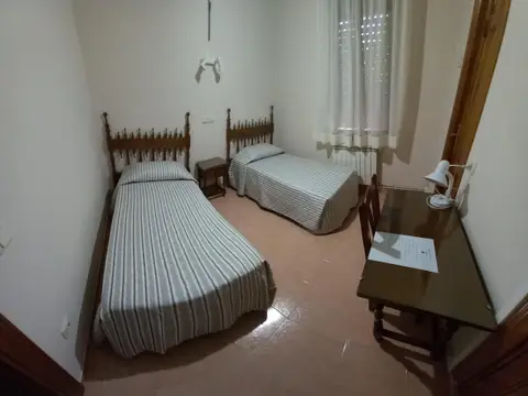 habitación compartida con dos camas y mesa de estudio