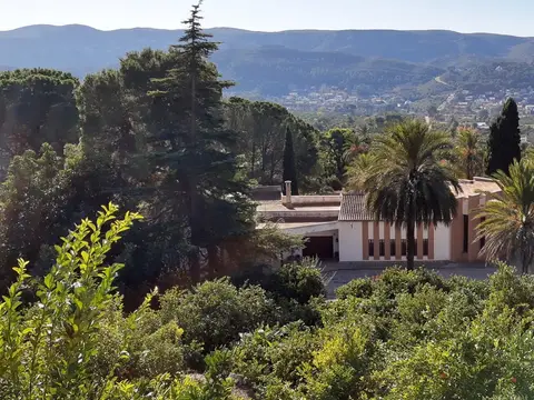 vista general de la casa desde el huerto, con la sierra al fondo
