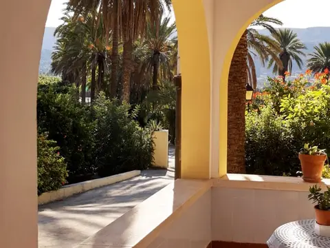 porche de arcos de la casa con mesa y vistas al jardín