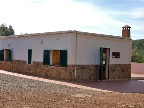 otra fachada de la casa, con zócalo de piedra