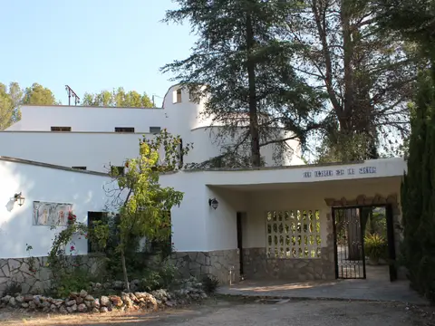 entrada porticada con el rótulo de azulejos «El Tossal de la Verge»
