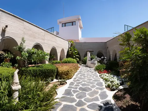 patio interior ajardinado con galería de arcos