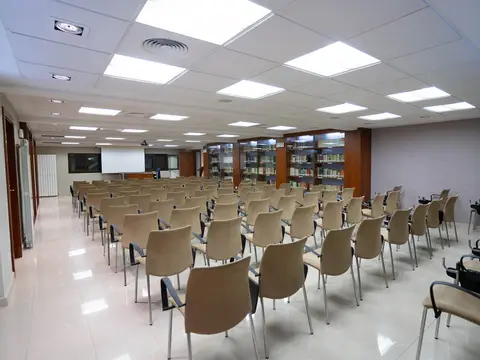 sala de conferencias con sillas y biblioteca