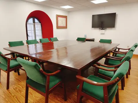 sala de reuniones con mesa grande y pantalla