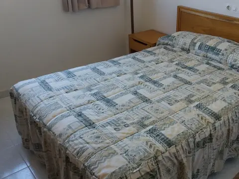 habitación con cama de matrimonio y mesilla