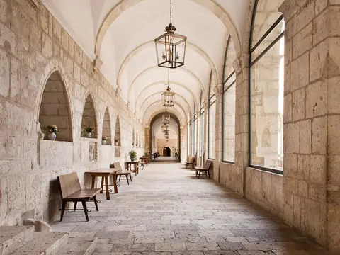 claustro de la hospedería, abovedado, con bancos y mesas