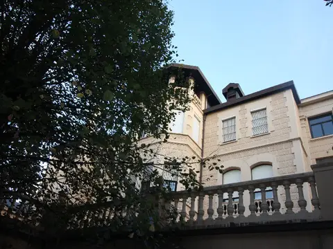 fachada del edificio de la casa vista desde el jardín, con la balaustrada de la terraza