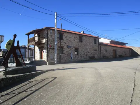 el albergue desde la N-525, con el monumento al peregrino delante
