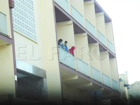 galerías porticadas del edificio «Amor Fraterno» (foto de prensa, con marca de agua; las personas del fondo aparecen pixeladas por el periódico)
